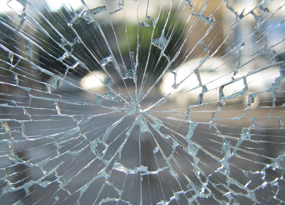 Cracked window glass pane showing a stress crack spreading from the edge